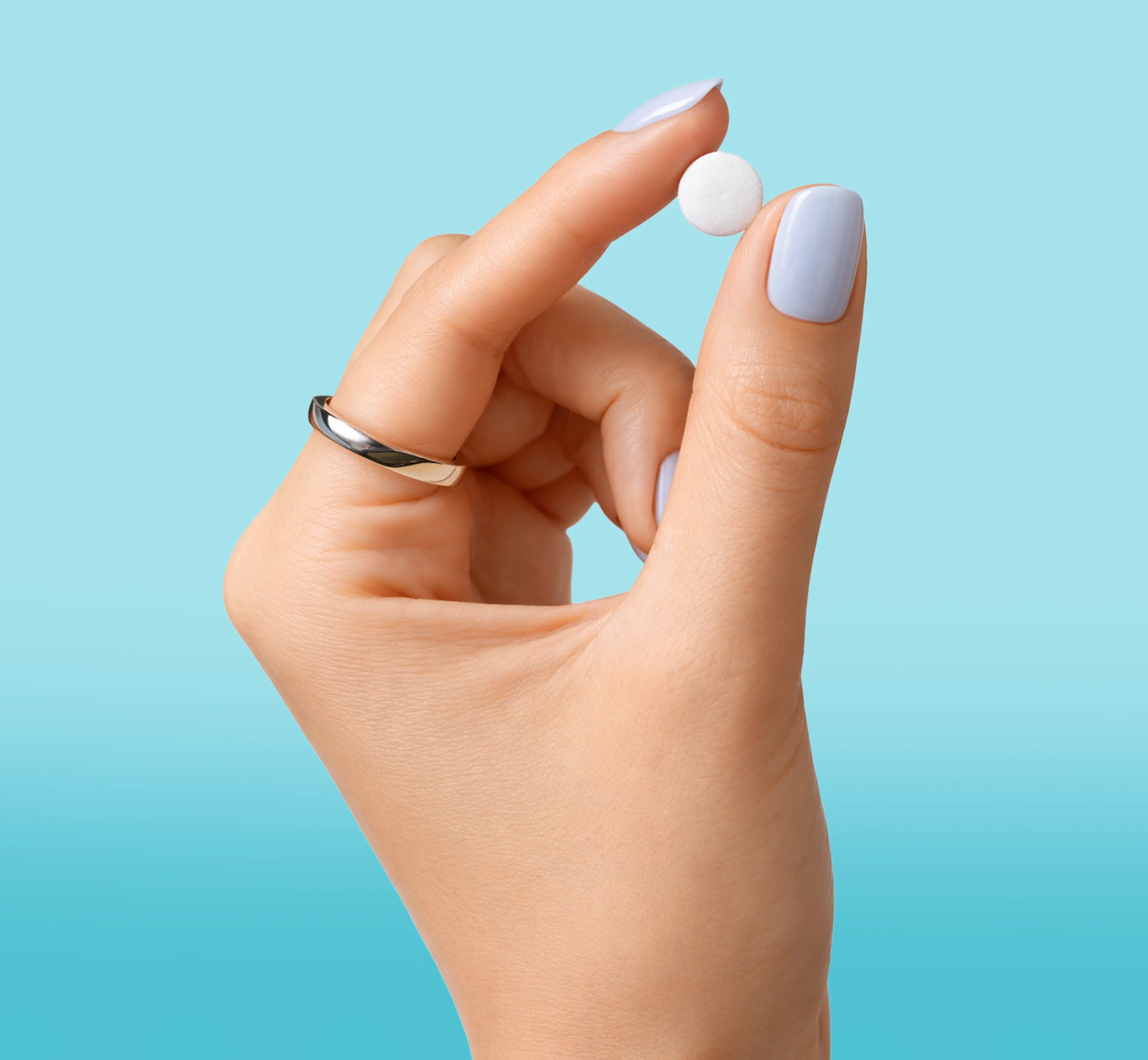 woman hand holding a white round pill