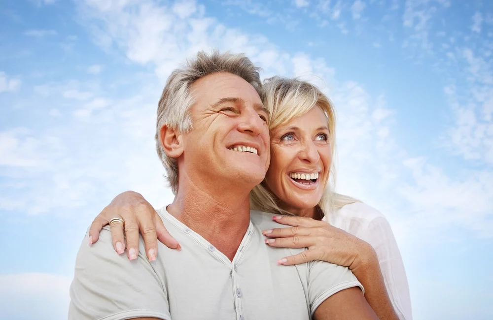 senior couple smiling hugging and beautiful sky background